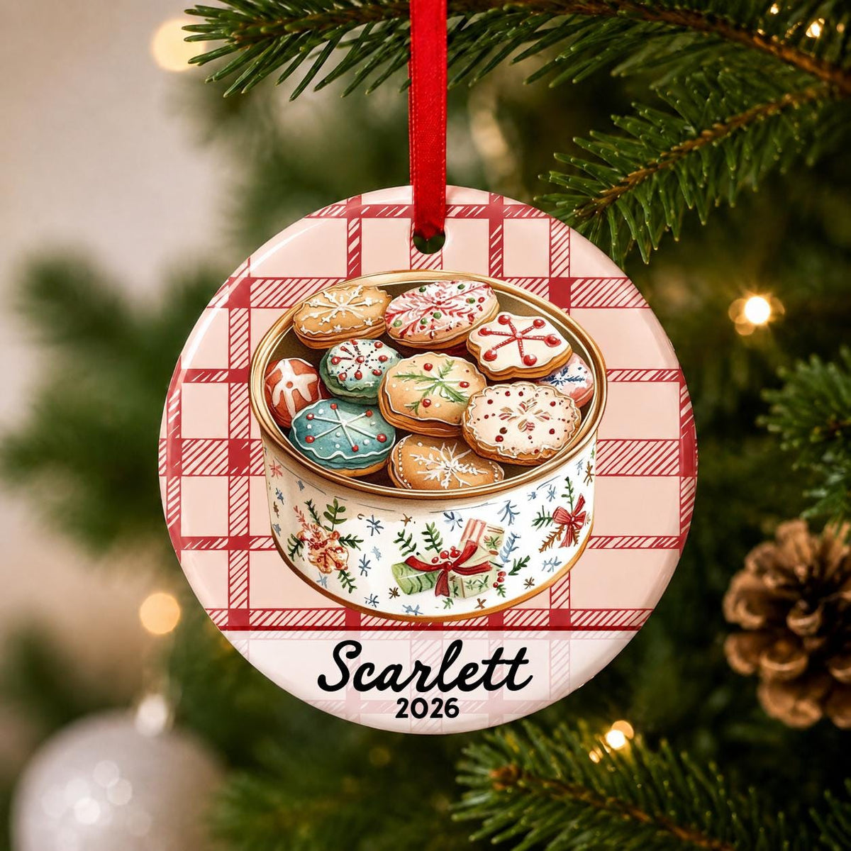 Close-up of the personalized Christmas cookie tin ceramic ornament with name and year on red plaid hanging on a Christmas tree