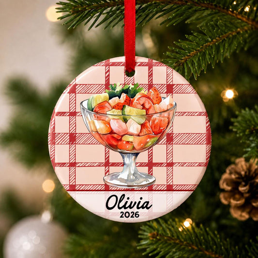 Close-up of the personalized shrimp cocktail ceramic ornament with name and year on red plaid hanging on a Christmas tree