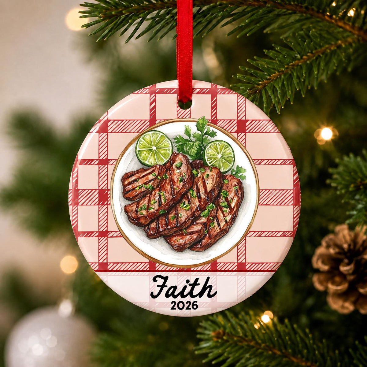 Close-up of the personalized carne asada ceramic ornament with name and year on red plaid hanging on a Christmas tree