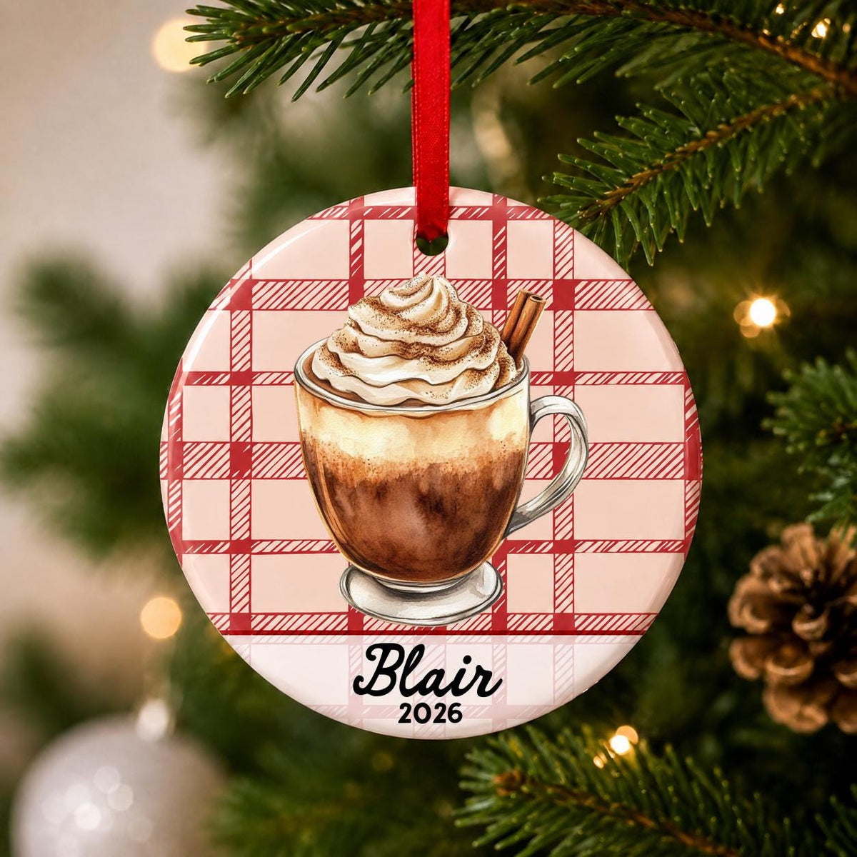 Close-up of the personalized Mexican hot chocolate ceramic ornament with name and year on red plaid hanging on a Christmas tree