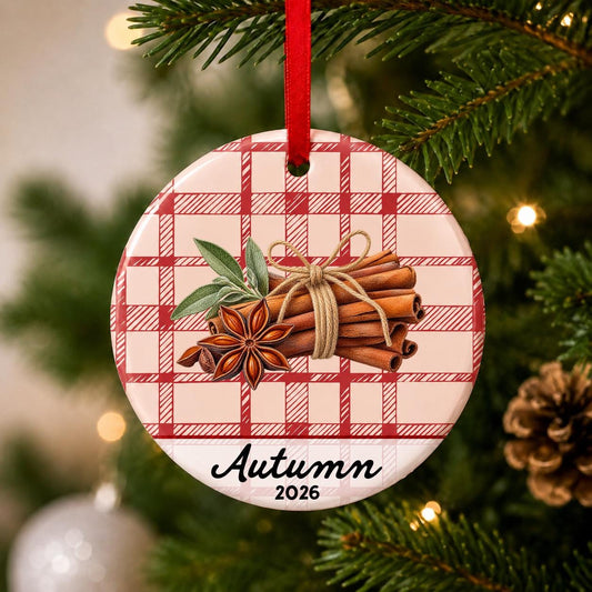 Close-up of the personalized cinnamon stick ceramic ornament with name and year on red plaid hanging on a Christmas tree