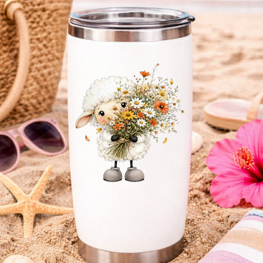 White Lamb Holding Wildflower Bouquet UV DTF sticker applied to a white travel tumbler on beach sand