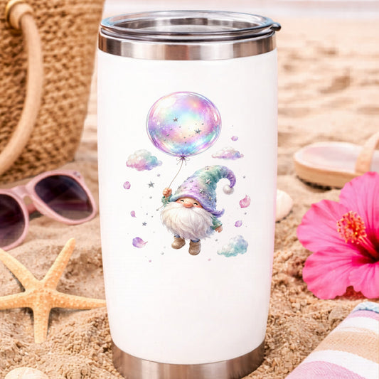 Gnome With Rainbow Bubble Balloon UV DTF sticker applied to a white travel tumbler on beach sand