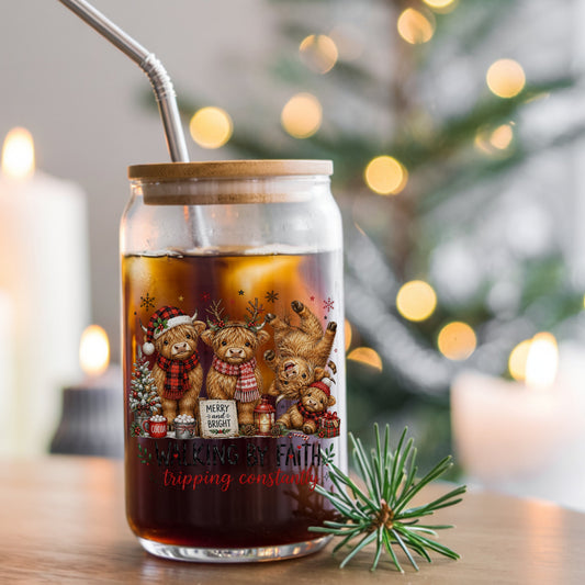 Walking By Faith Christmas Highland Cows UV DTF sticker applied to a glass can cup of iced coffee with a straw