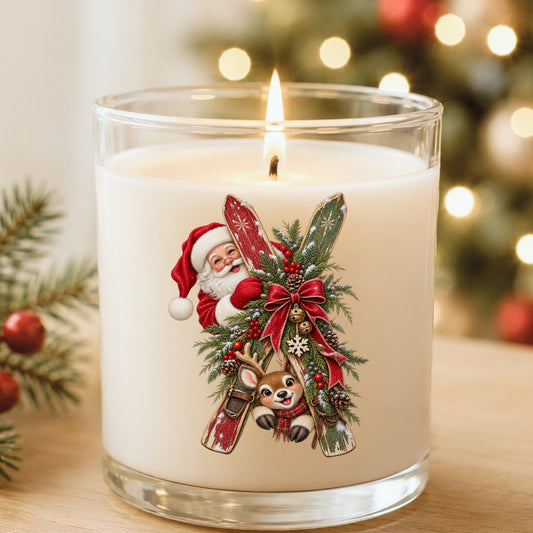 Santa And Reindeer With Wooden Skis UV DTF sticker applied to a white candle in a glass holder near Christmas lights