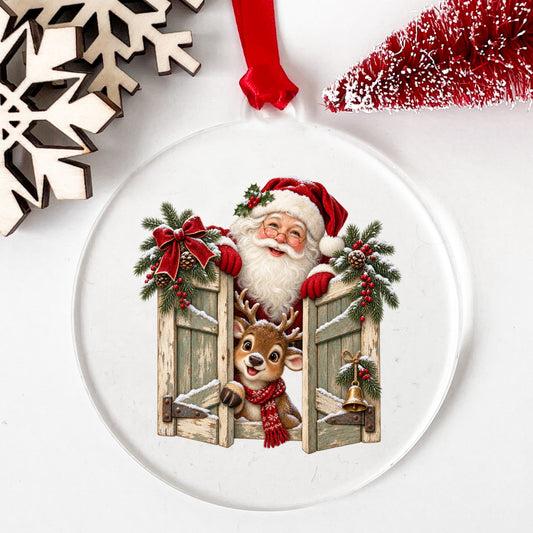 Santa And Reindeer Behind Wooden Shutters UV DTF sticker applied to a clear round acrylic ornament with a red ribbon