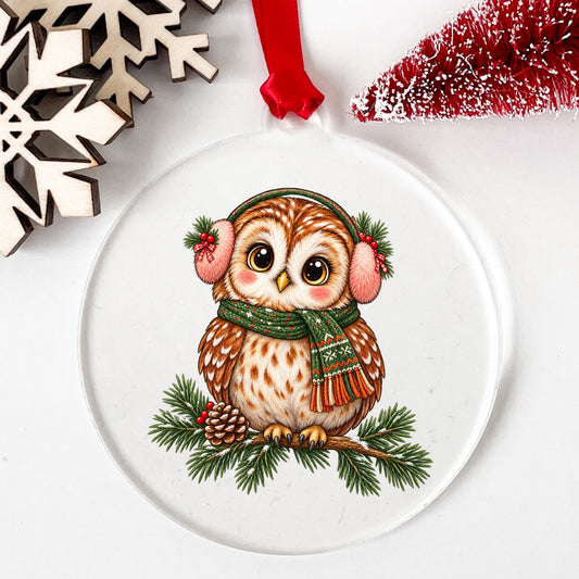 Owl With Earmuffs And Scarf On Pine Branch UV DTF sticker applied to a clear round acrylic ornament with a red ribbon