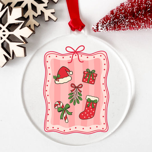 Coquette Christmas Icons Pink Frame UV DTF sticker applied to a clear round acrylic ornament with a red ribbon