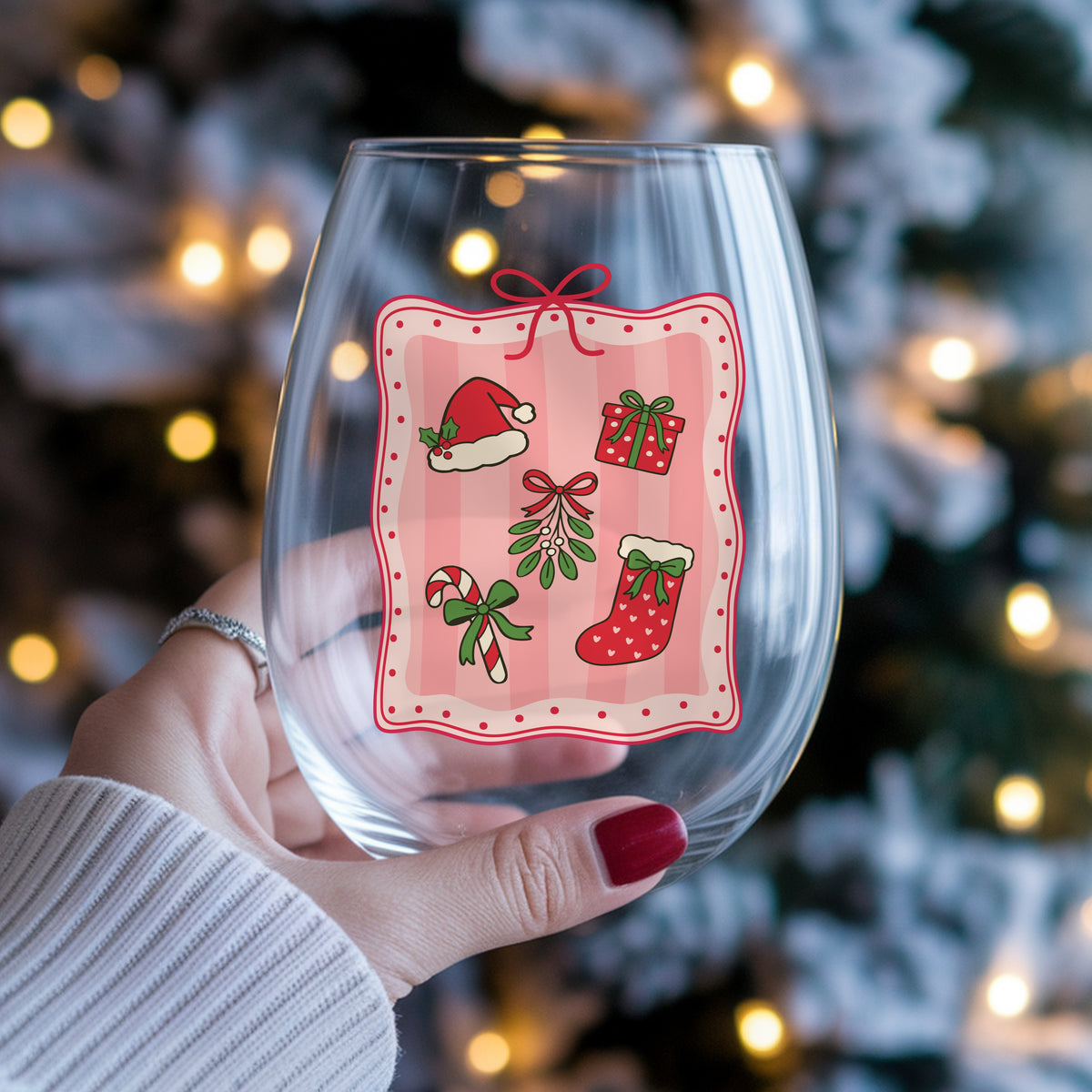 Coquette Christmas Icons Pink Frame UV DTF sticker applied to a stemless wine glass held in hand