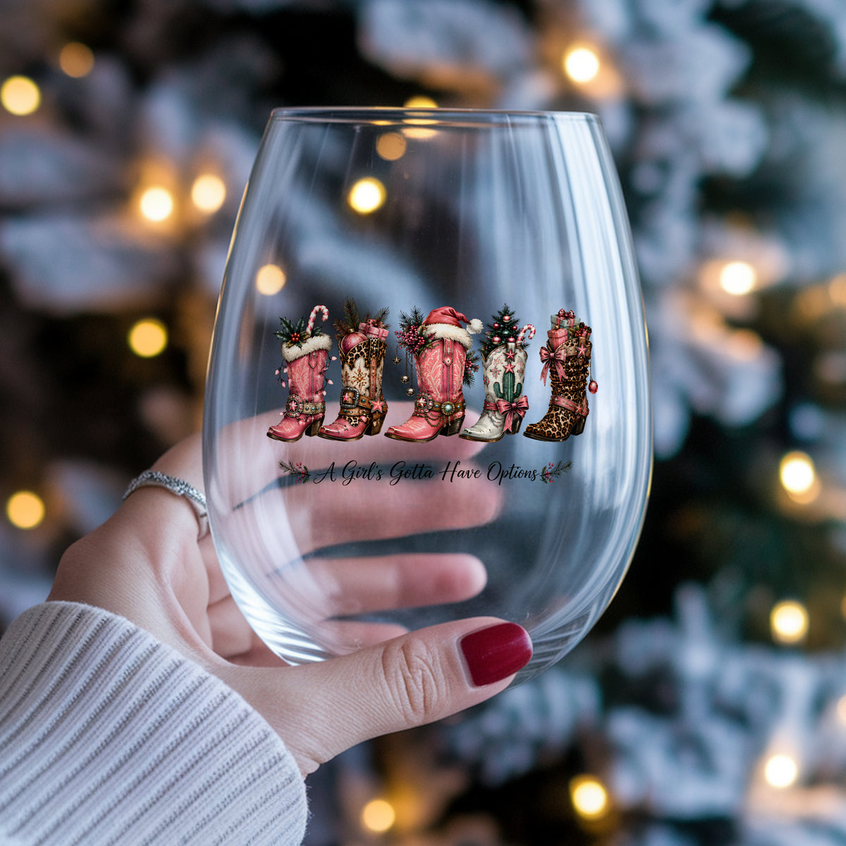 A Girls Gotta Have Options Christmas Boots UV DTF sticker applied to a stemless wine glass held in hand
