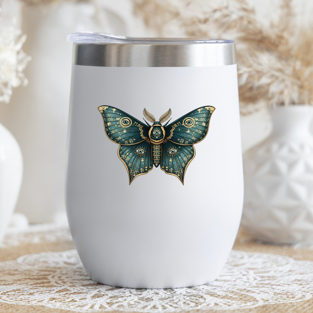 Teal Rune Moth All Seeing Eye UV DTF sticker applied to a white stemless tumbler with a lid