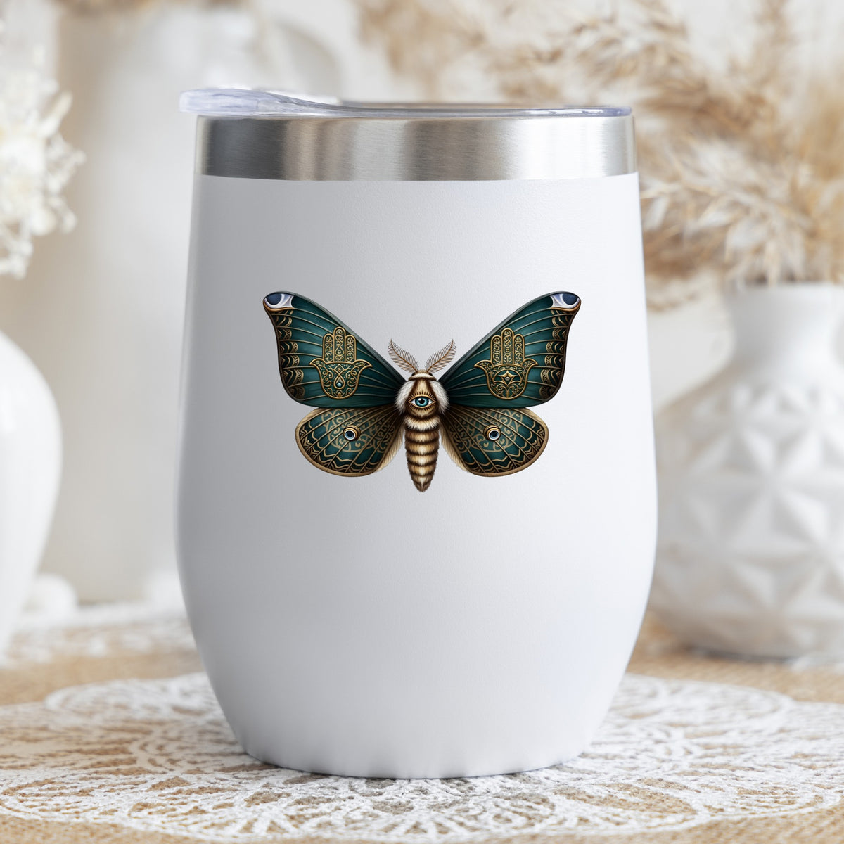 Hamsa Hand Moth UV DTF sticker applied to a white stemless tumbler with a lid