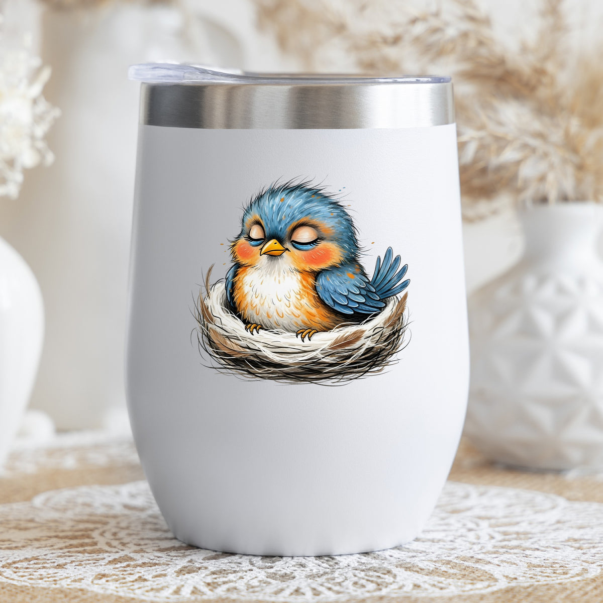 Sleeping Bird In Nest UV DTF sticker applied to a white stemless tumbler with a lid