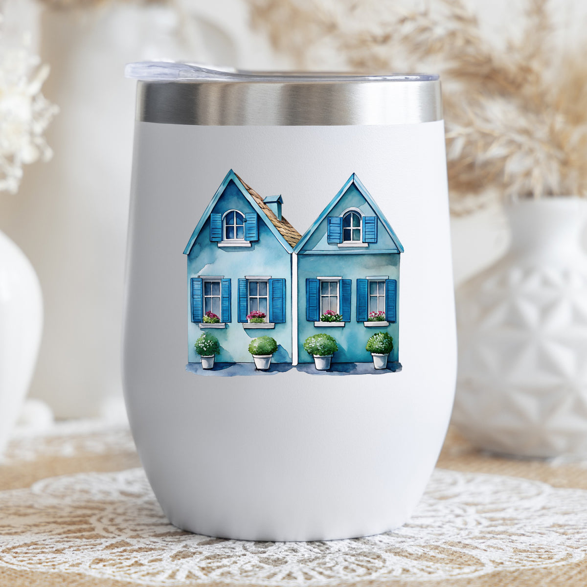 Two Blue Coastal Cottages UV DTF sticker applied to a white stemless tumbler with a lid