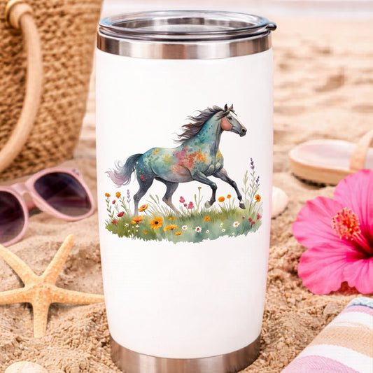 Floral Horse Running Through Wildflowers UV DTF sticker applied to a white travel tumbler on beach sand