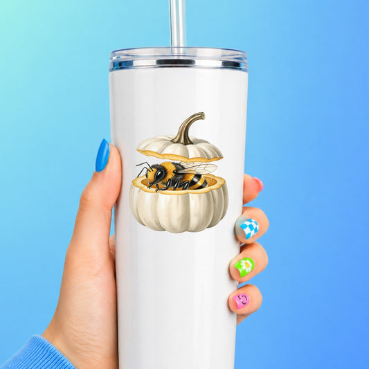 Sleepy Bee Inside White Pumpkin UV DTF sticker applied to a white straw tumbler on a blue background
