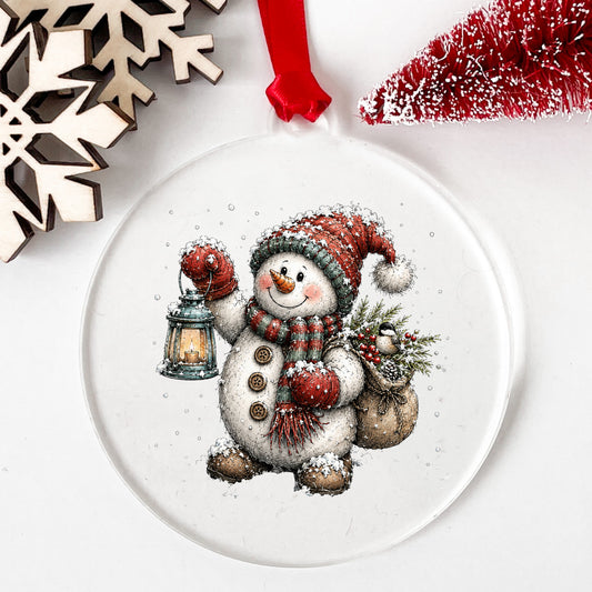 Walking Snowman With Burlap Sack UV DTF sticker applied to a clear round acrylic ornament with a red ribbon