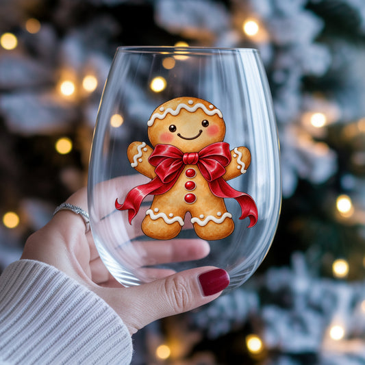 Gingerbread Man With Red Bow UV DTF sticker applied to a stemless wine glass held in hand