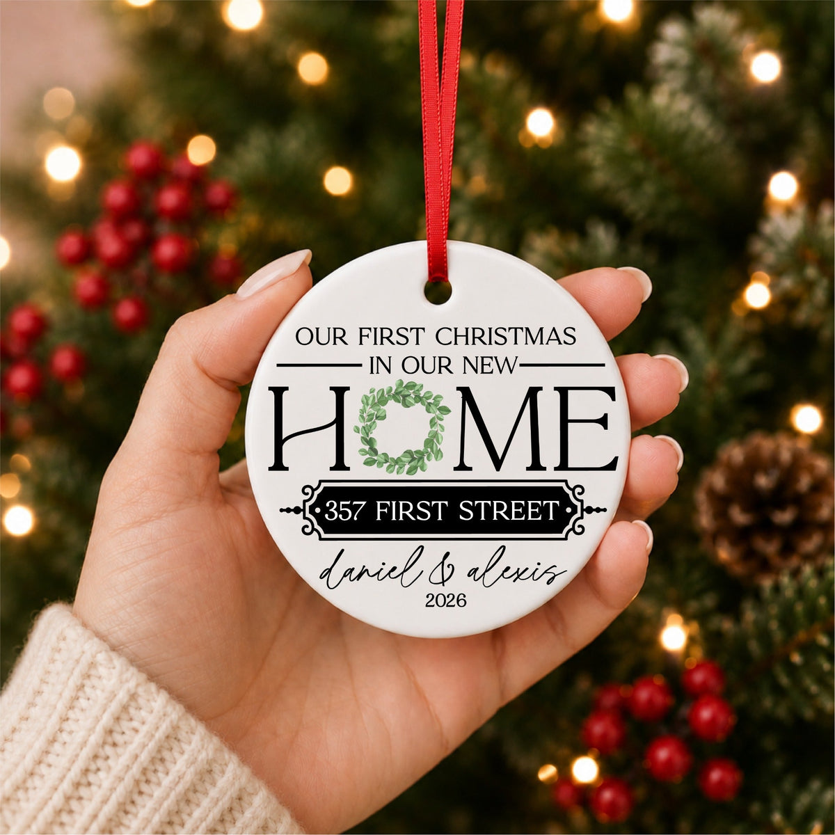 Personalized Our First Christmas in Our New Home ceramic ornament hanging with red ribbon