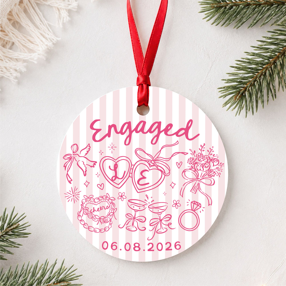 Personalized pink striped engagement ornament with initials and full date, styled flat lay hero view