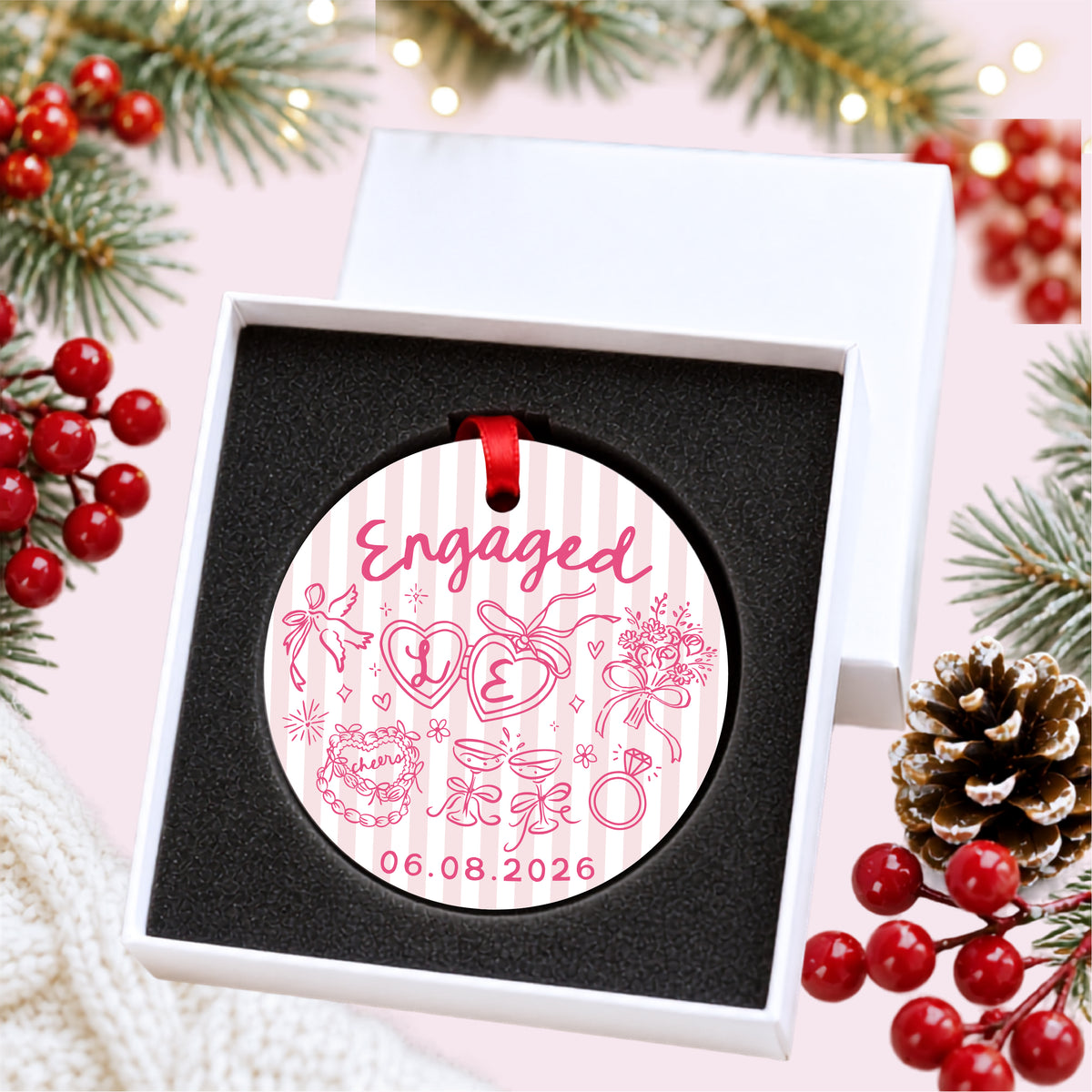 Personalized pink striped engagement ornament with initials and full date, presented inside a white gift box with protective foam