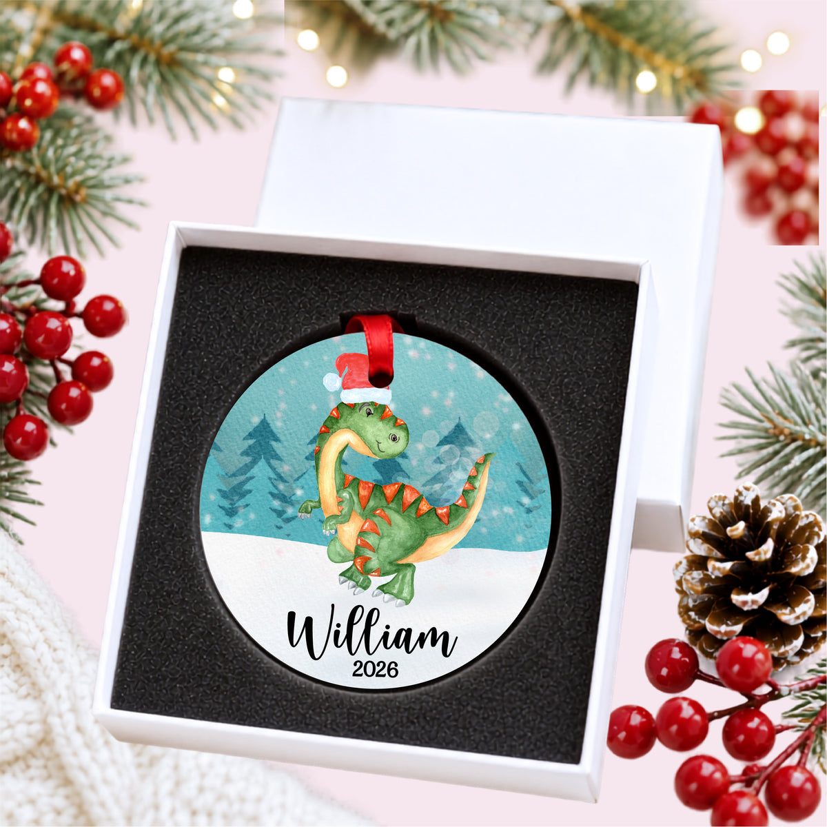 Personalized watercolor Christmas dinosaur ornament with child's name and year, presented inside a white gift box with protective foam