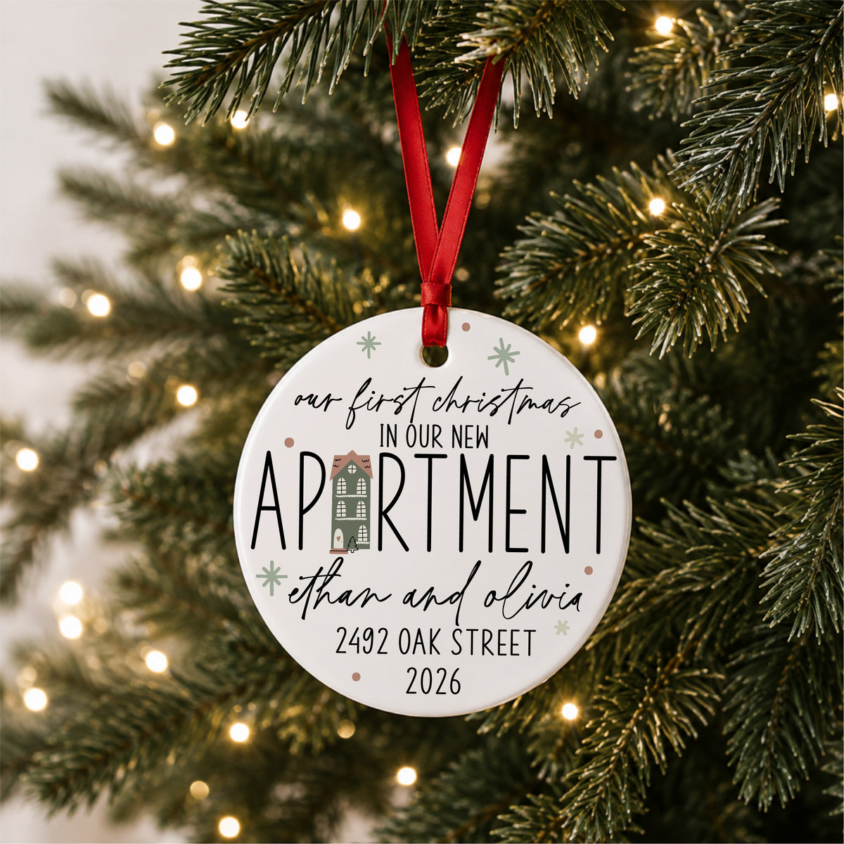 Personalized first Christmas in our new apartment ornament with address, names and year, hanging on a lit Christmas tree