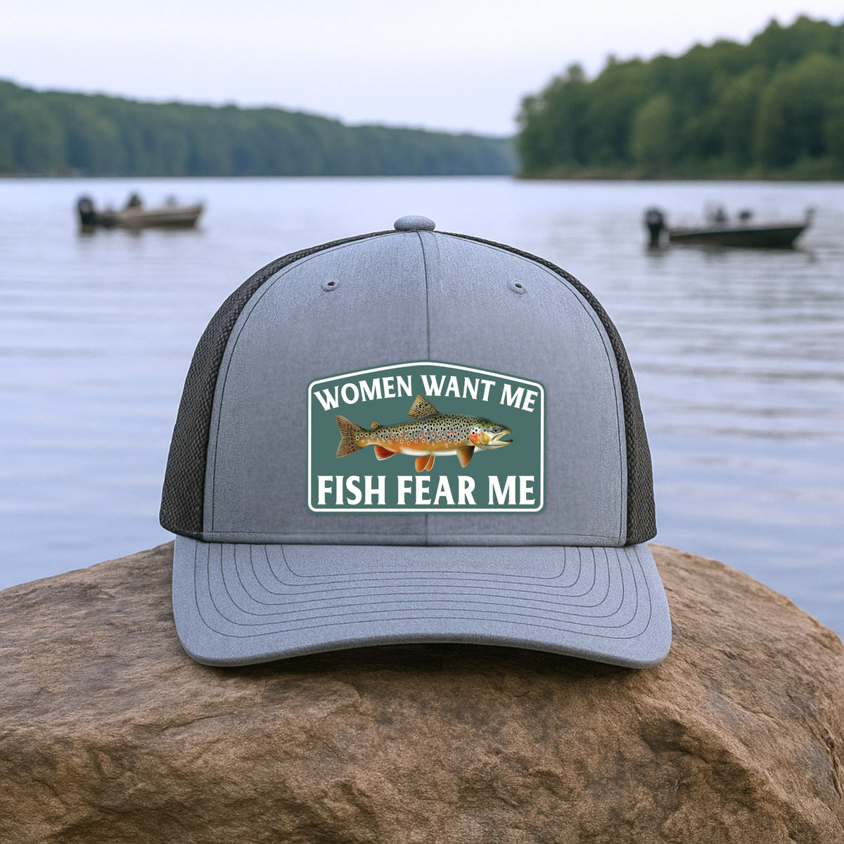 Fish Fear Me Richardson 112 hat resting on a rock near a lake, outdoor fishing-themed still life