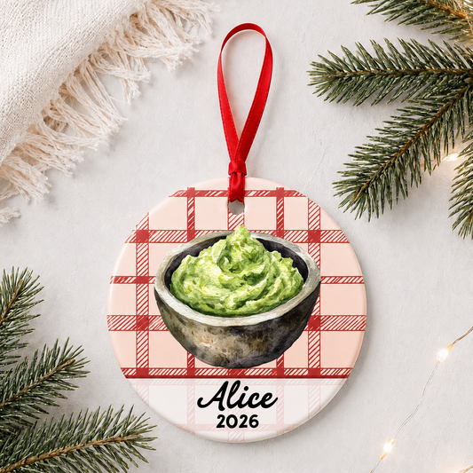 Personalized guacamole ceramic ornament with name and year on red plaid styled with pine branches on a soft white background
