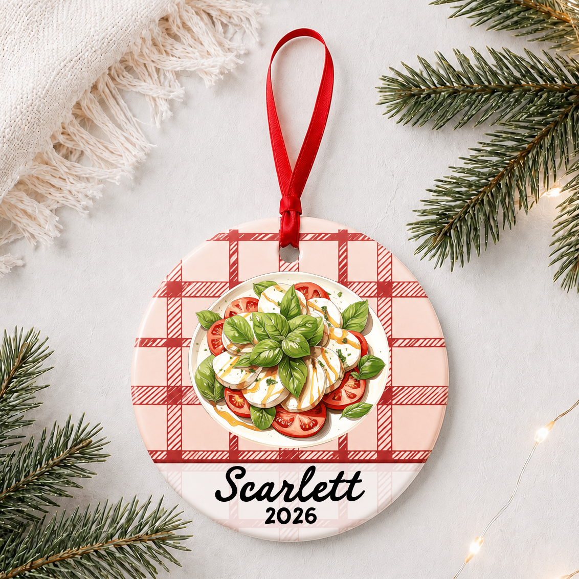 Personalized caprese salad ceramic ornament with name and year on red plaid styled with pine branches on a soft white background
