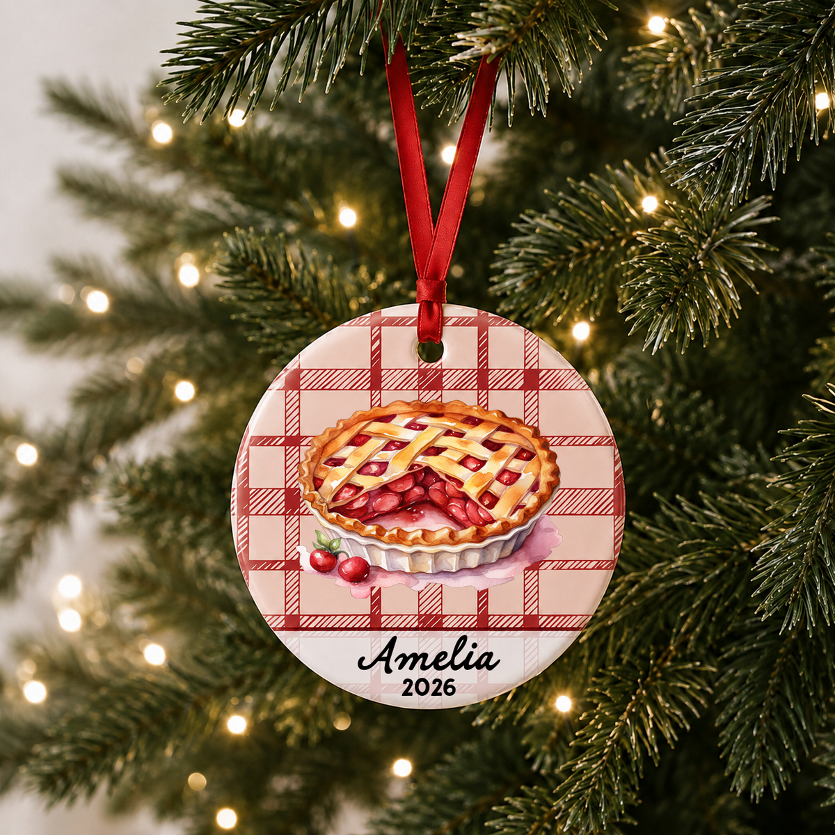 Personalized cherry pie ceramic ornament hanging on a Christmas tree with red ribbon