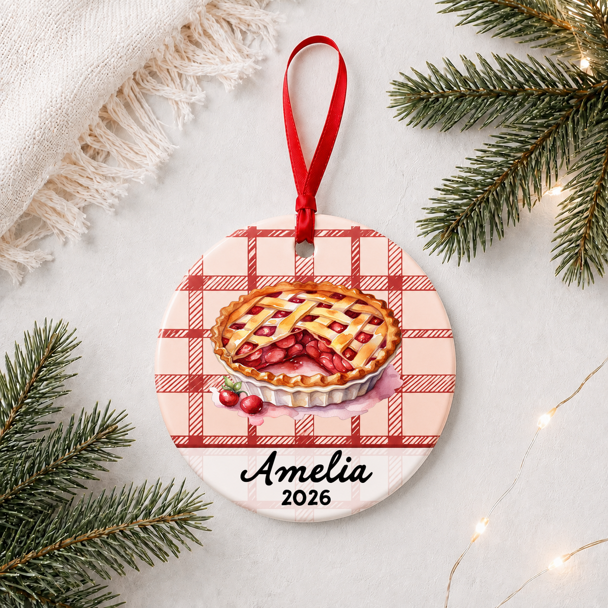 Personalized cherry pie ceramic ornament with name and year in a bright holiday flat lay
