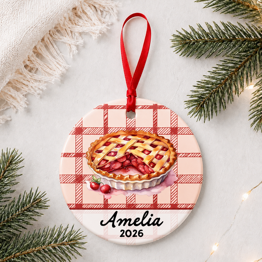 Personalized cherry pie ceramic ornament with name and year in a bright holiday flat lay