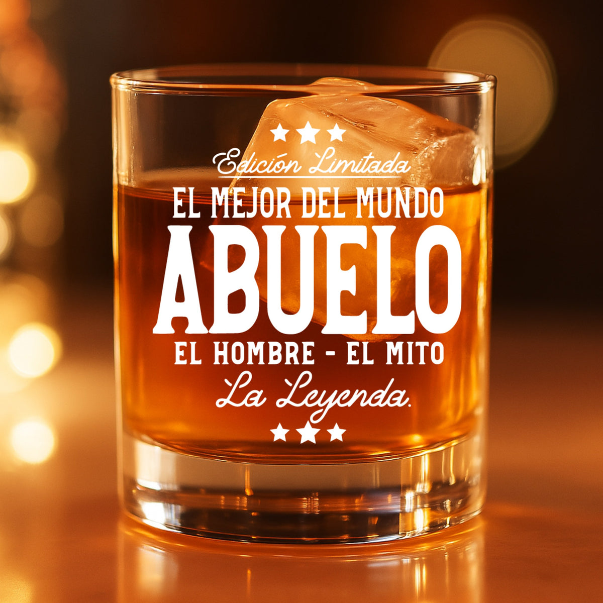  Engraved World's Best Abuelo whiskey glass filled with bourbon and ice, glowing in warm ambient light