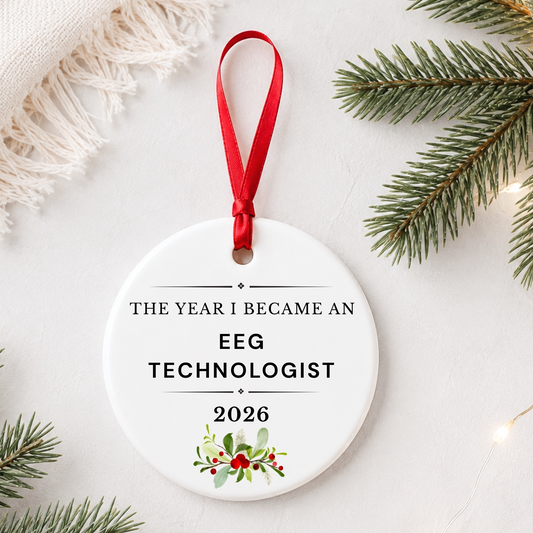 EEG Technologist 2026 ceramic ornament reading The Year I Became an EEG Technologist styled with pine branches on a soft white background