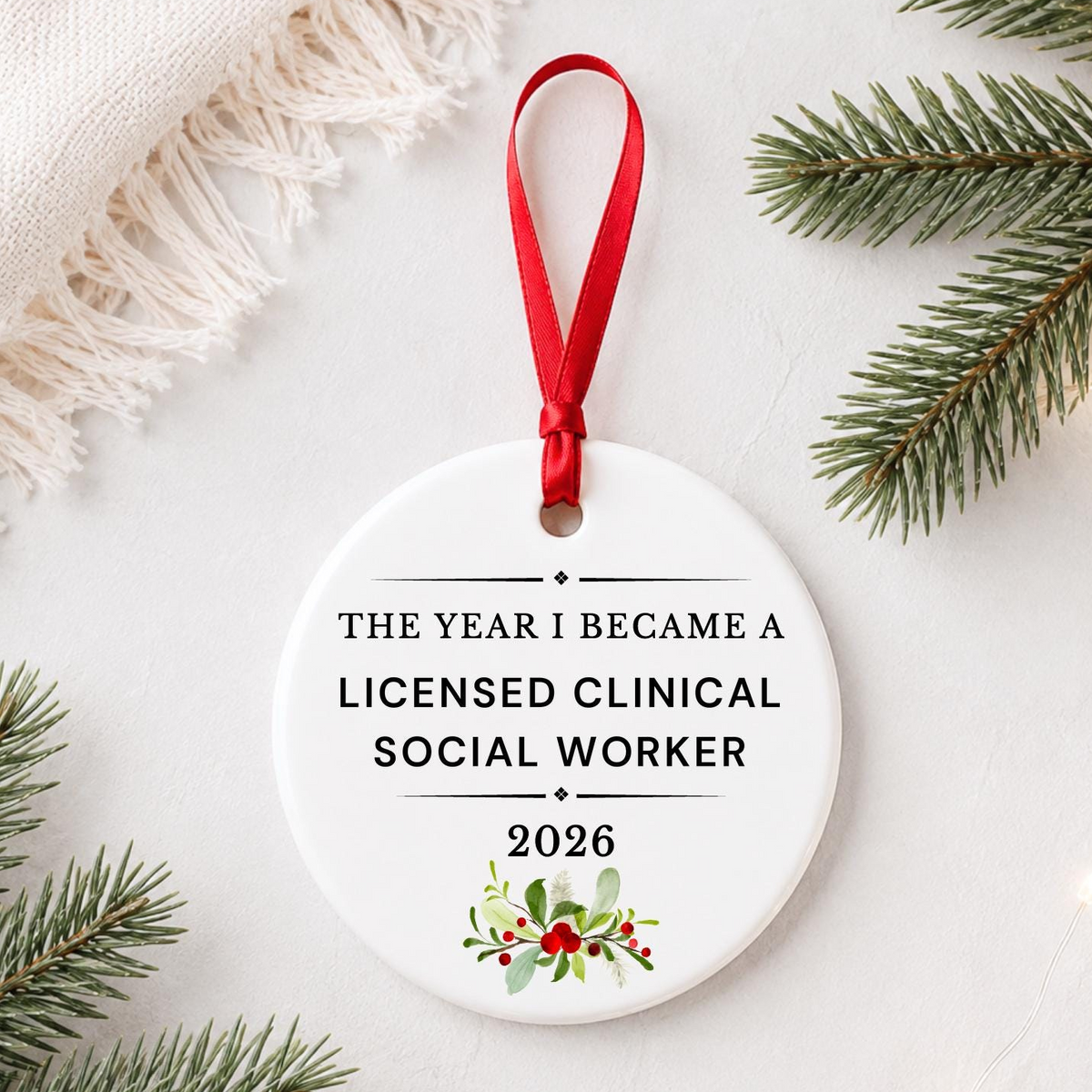 Licensed Clinical Social Worker 2026 ceramic ornament reading The Year I Became a Licensed Clinical Social Worker styled with pine branches on a soft white background