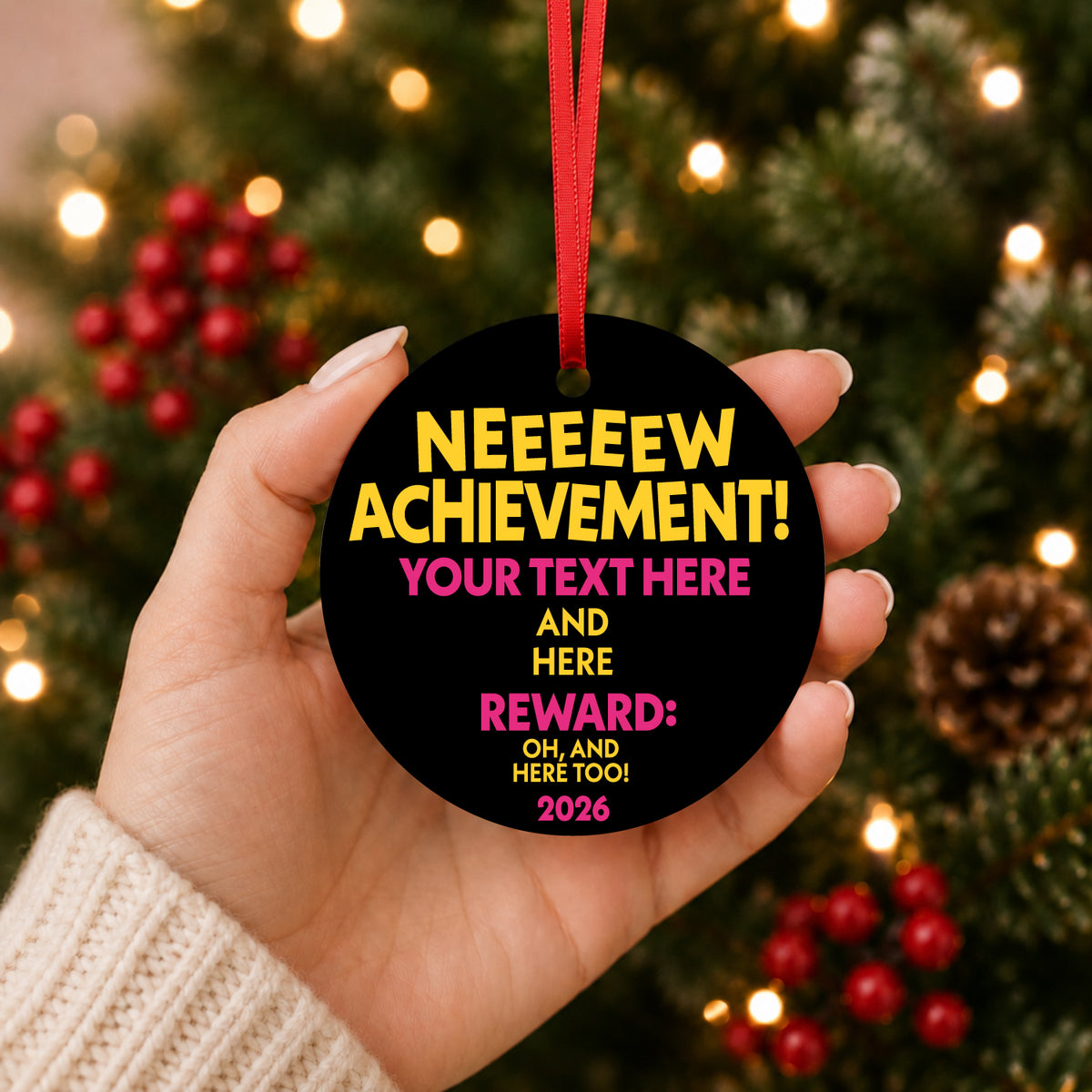 Custom achievement ornament held in a hand in front of a lit Christmas tree