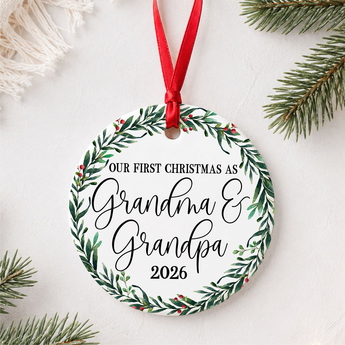 Our First Christmas as Grandma and Grandpa ceramic ornament with personalized year, styled with evergreen branches