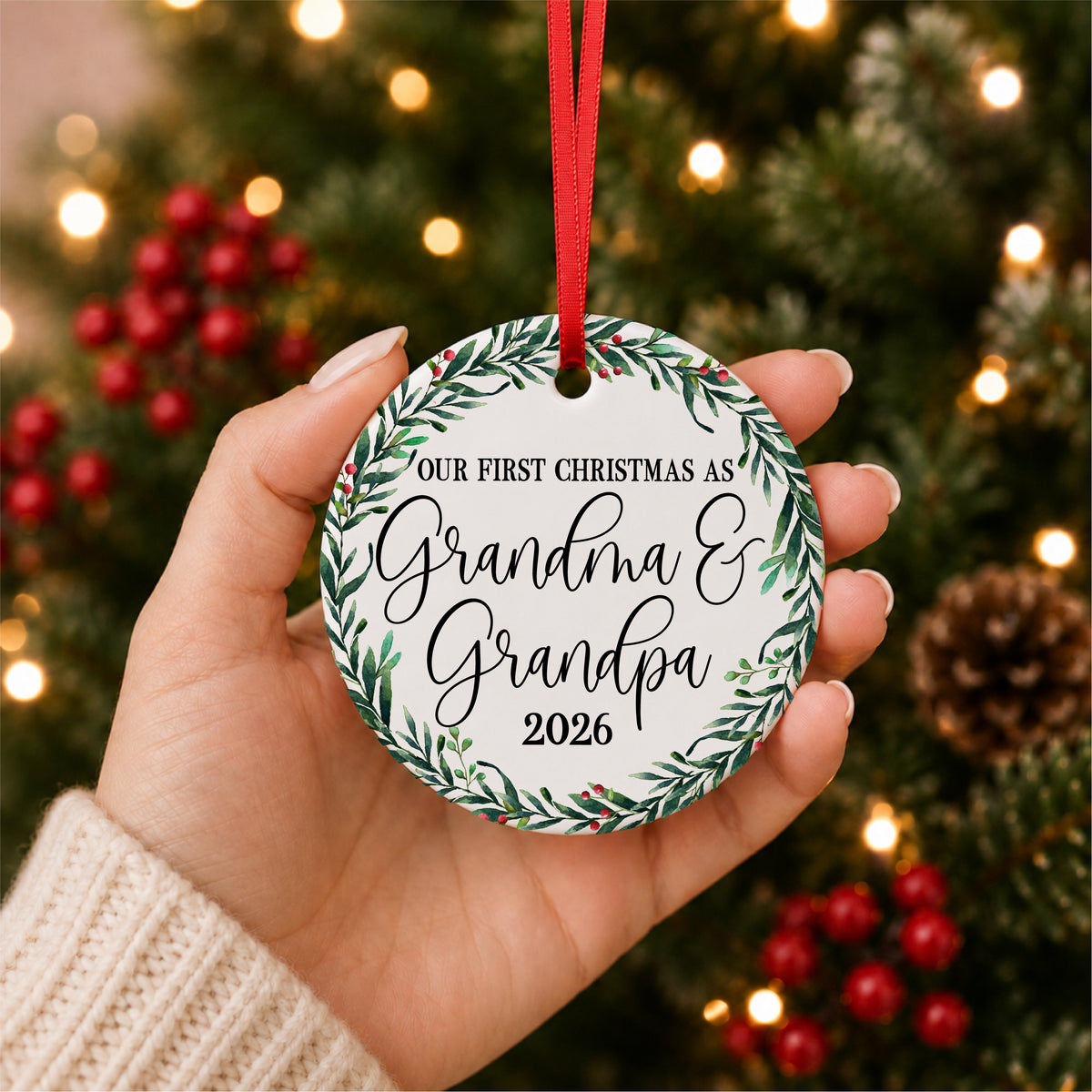 Hand holding an Our First Christmas as Grandma and Grandpa ornament with personalized year