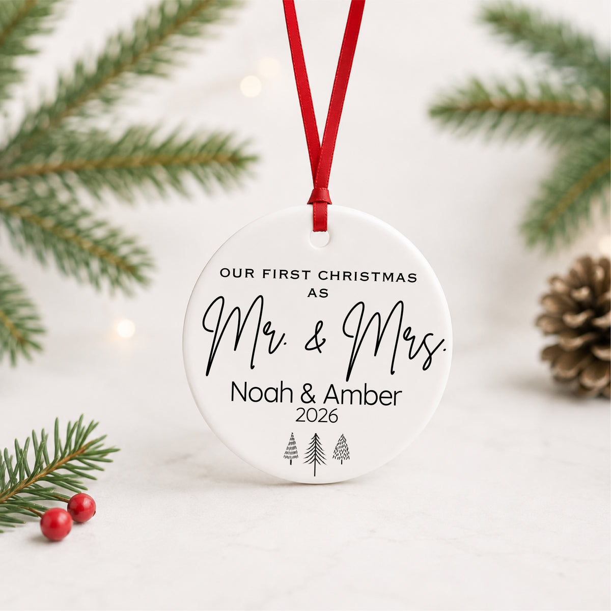 Personalized Mr and Mrs first Christmas ornament hanging against a light holiday backdrop