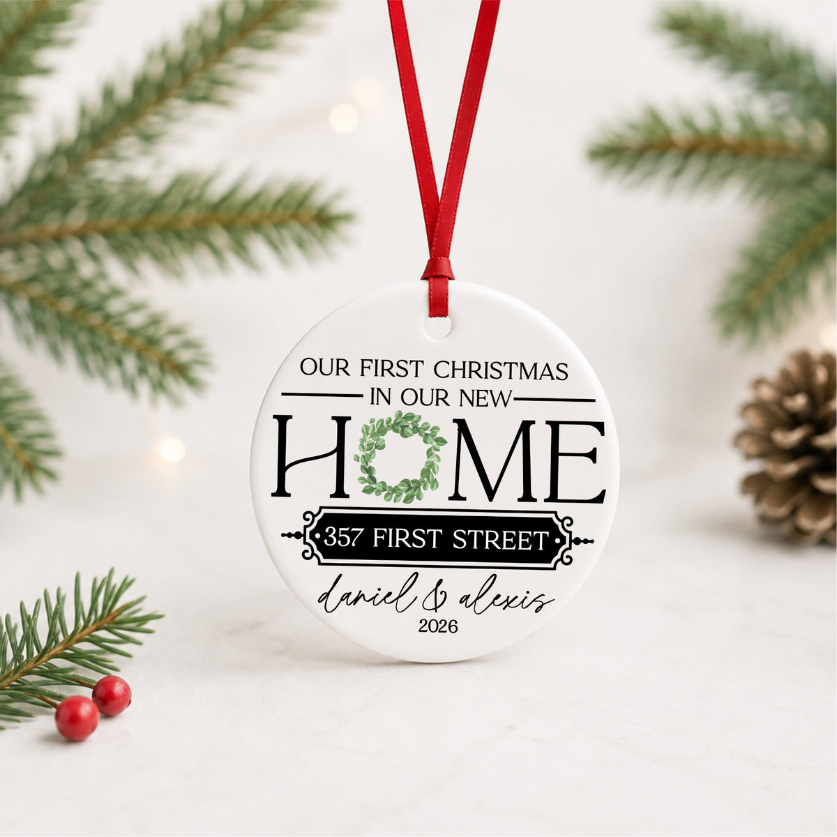 Personalized new home Christmas ceramic ornament with greenery and red ribbon