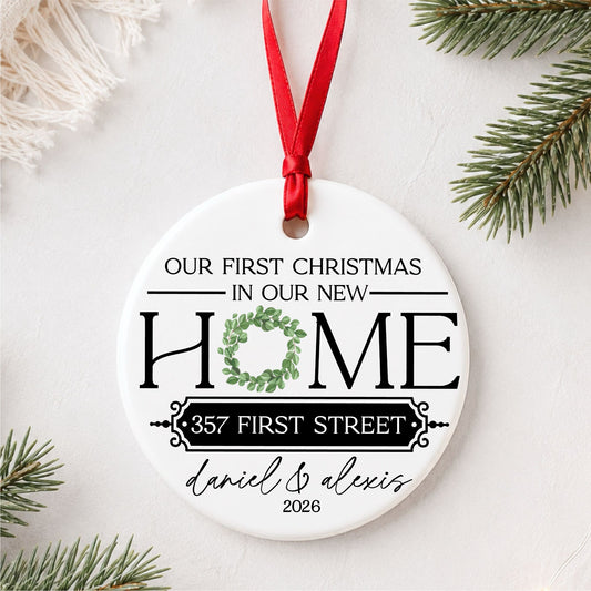 Hand holding personalized Our First Christmas in Our New Home ceramic ornament