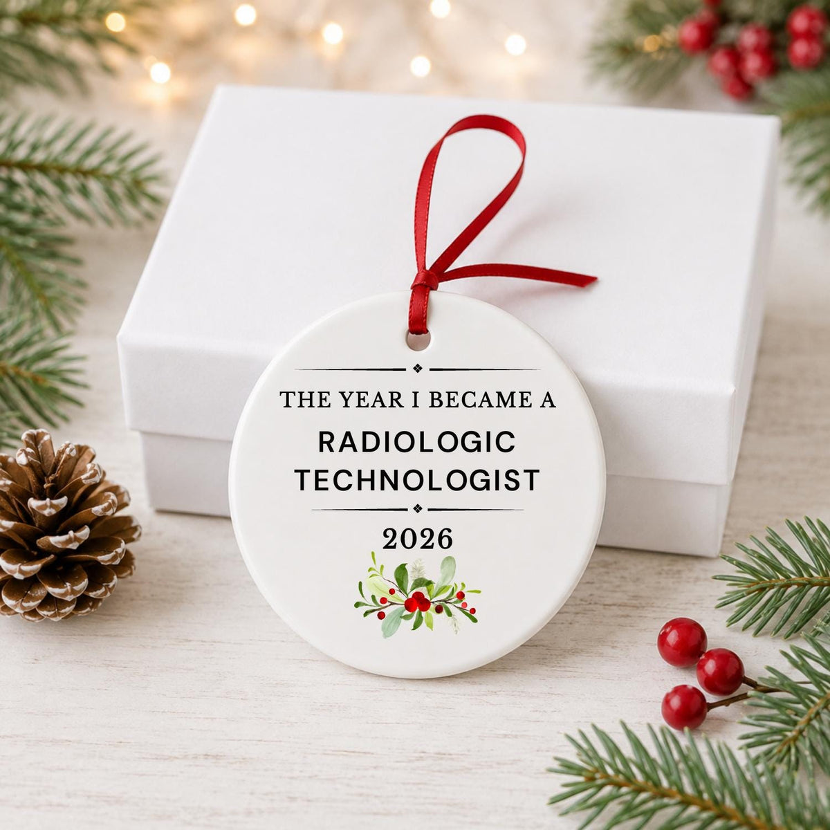 Radiologic Technologist 2026 ceramic ornament reading The Year I Became a Radiologic Technologist in front of a white gift box with pinecones and red berries