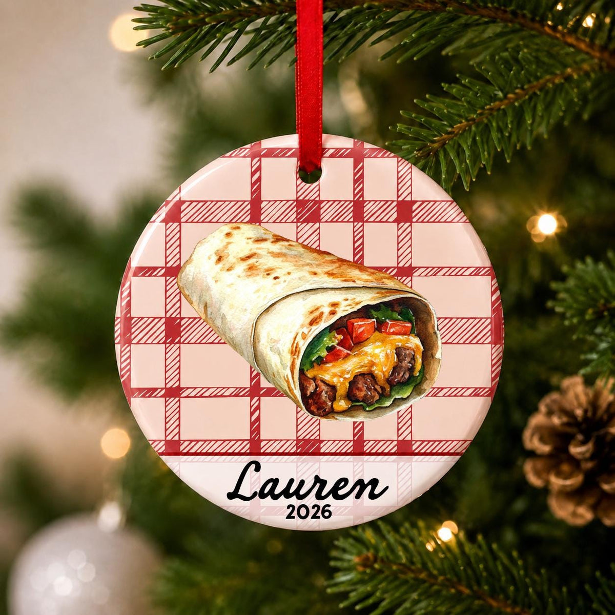 Close-up of the personalized burrito ceramic ornament with name and year on red plaid hanging on a Christmas tree