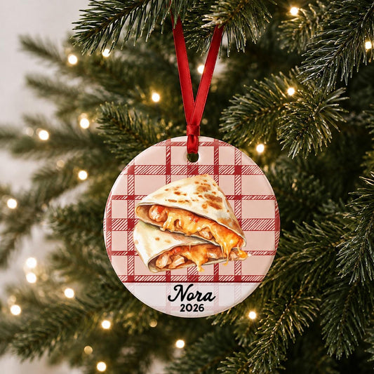 Personalized quesadilla ceramic ornament with name and year on red plaid hanging on a lit Christmas tree