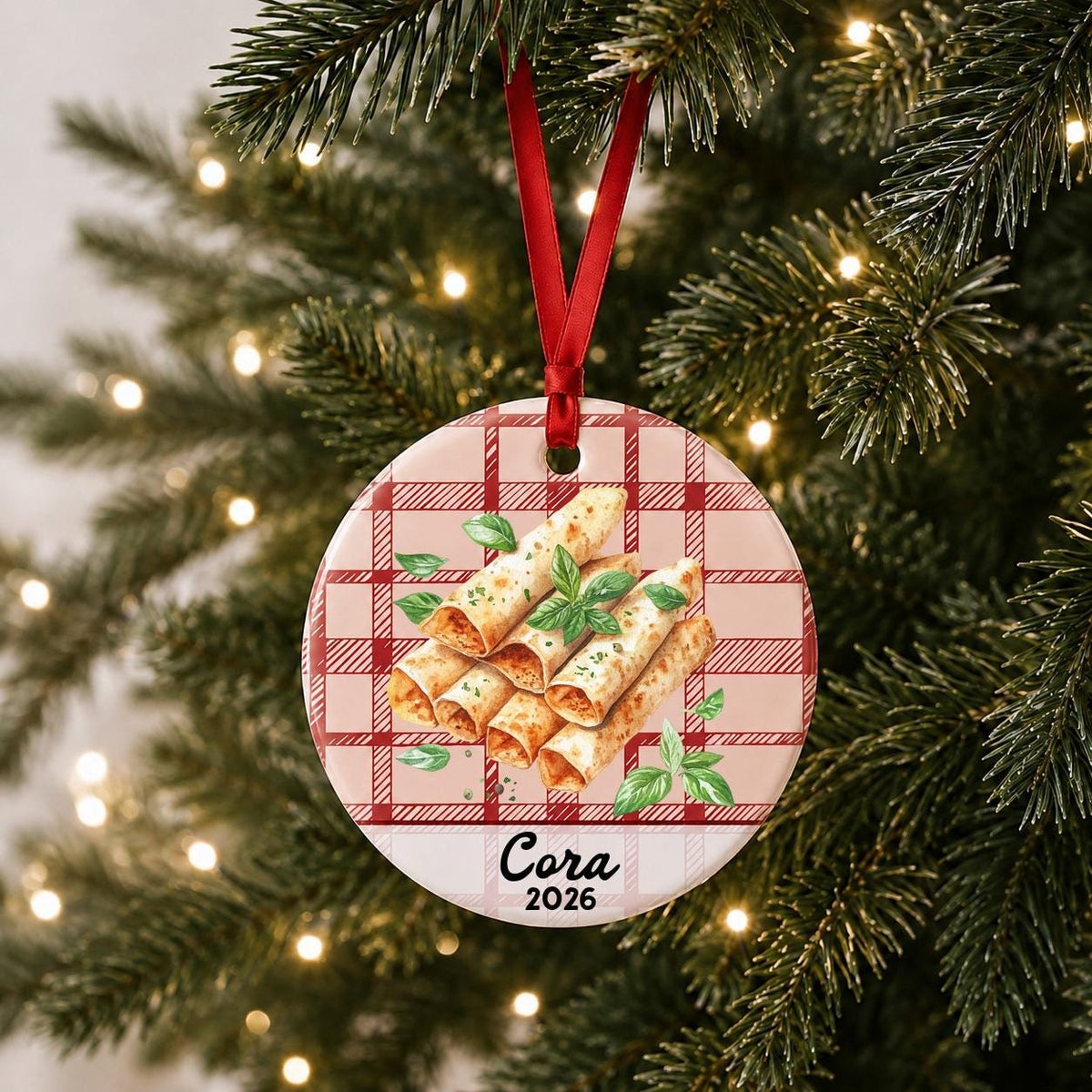 Personalized taquito ceramic ornament with name and year on red plaid hanging on a lit Christmas tree