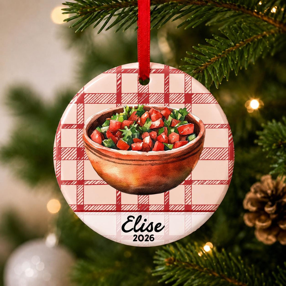 Close-up of the personalized pico de gallo ceramic ornament with name and year on red plaid hanging on a Christmas tree