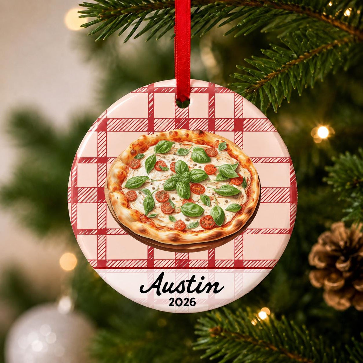 Close-up of the personalized Margherita pizza ceramic ornament with name and year on red plaid hanging on a Christmas tree
