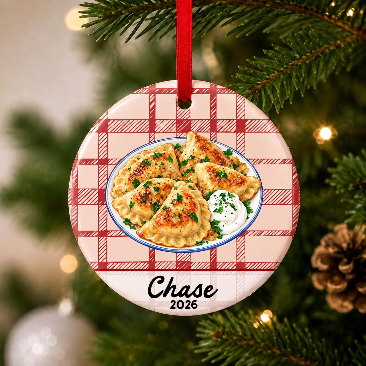 Close-up of the personalized pierogi ceramic ornament with name and year on red plaid hanging on a Christmas tree
