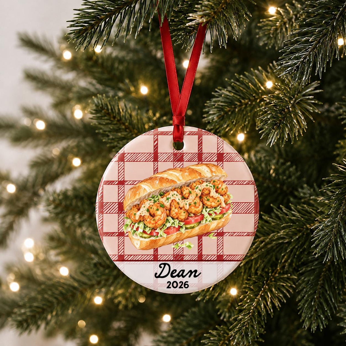 Personalized shrimp po' boy ceramic ornament with name and year on red plaid hanging on a lit Christmas tree